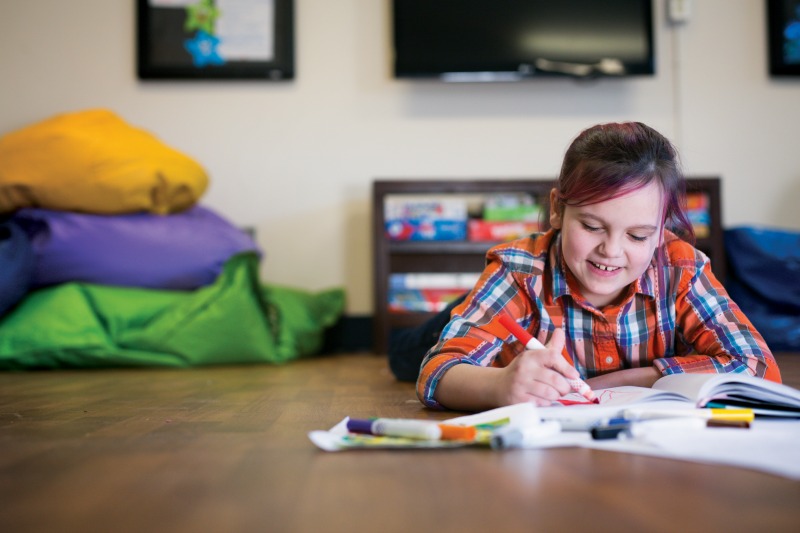 a young girl drawing on the floor