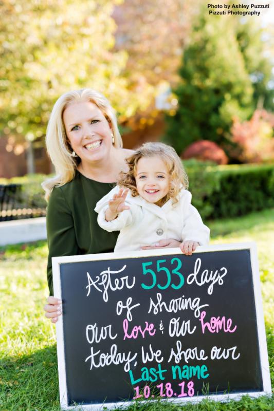 a woman and a young girl holding a sign